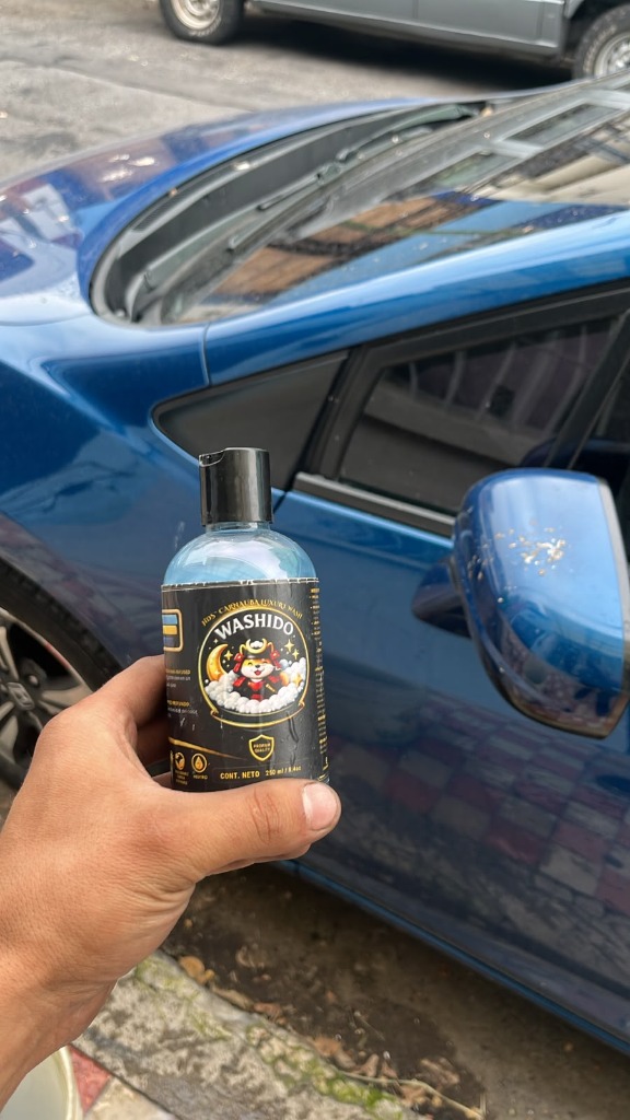 Honda Civic antes del lavado con botella Washido Carnauba en mano